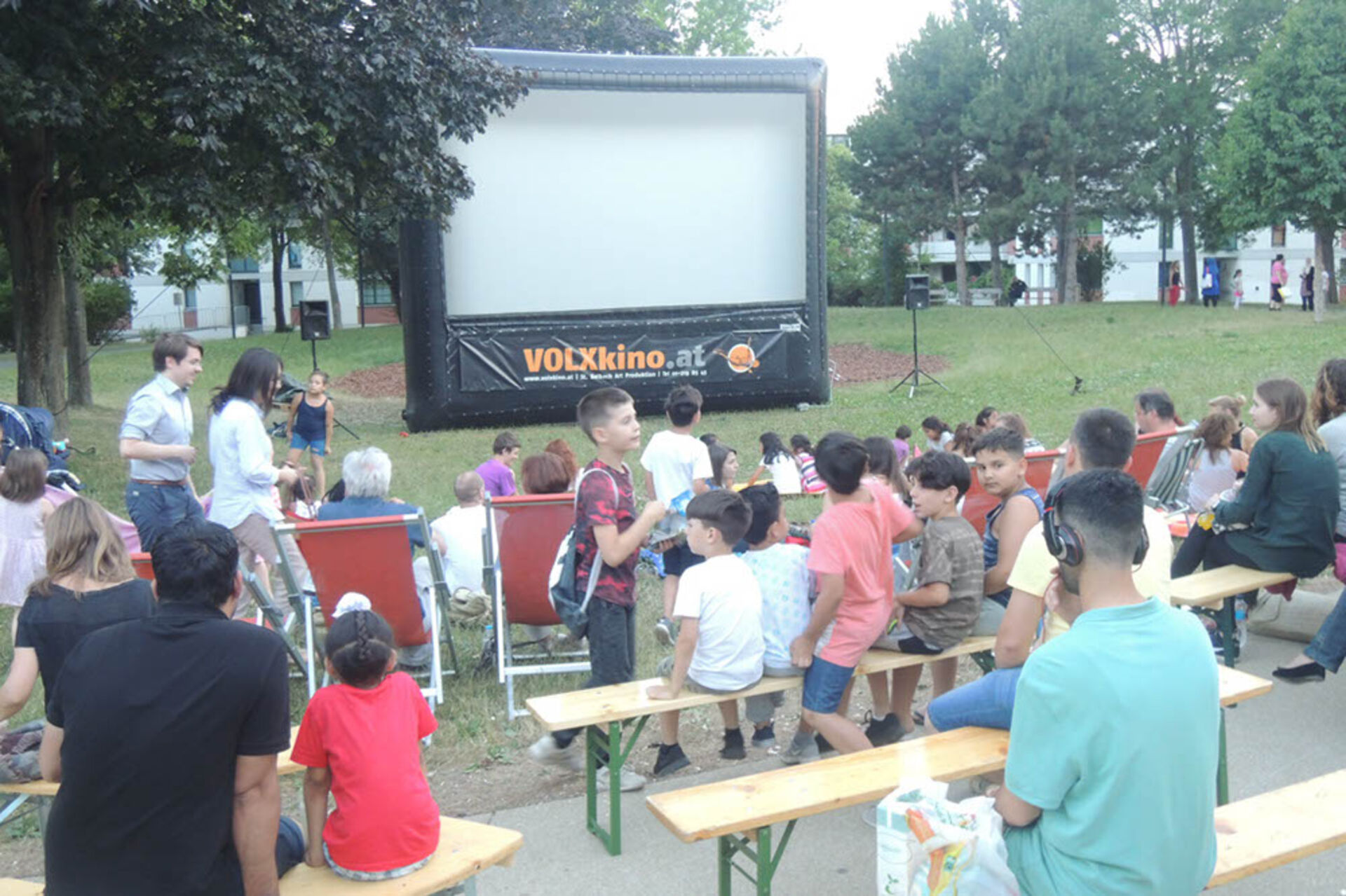 Viele BesucherInnen nehmen ihre Plätze beim Sommerkino ein.