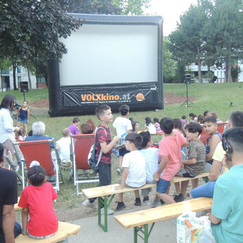 Viele BesucherInnen nehmen ihre Plätze beim Sommerkino ein.