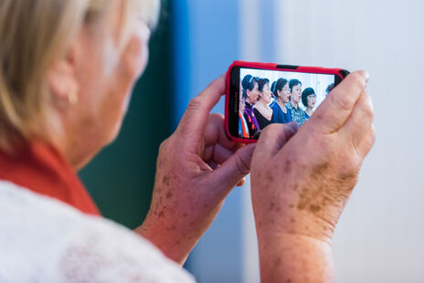 Begeisterte Zuseherin fotografiert den Auftritt des chinesischen Chors