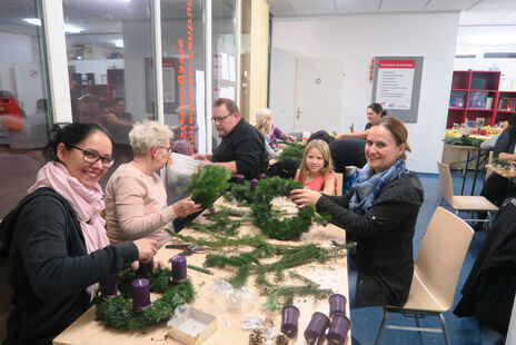 Mit viel Spaß dabei: Groß und Klein beim Adventkranzbinden