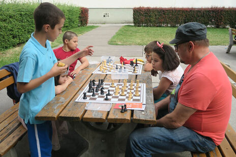 Die Kleinen lernen von den Großen das Schachspielen.