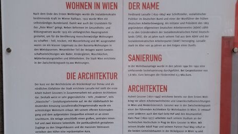 Informationstafel mit Text zu Wohnprojekt Lassalle-Hof in Wien, Baujahr 1925 bis 1926, Architekten Hubert Gessner und Fritz Waage, mit Abschnitten zu Architektur, Name, Sanierung und Architekten, sowie Logos von Wien und Wiener Wohnen