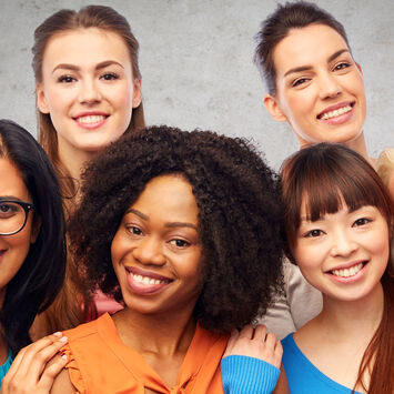 Sechs Frauen verschiedener ethnischer Herkunft lachen in die Kamera.