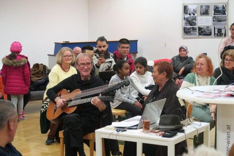 Gitarrespielender Bewohner bei Präsentation