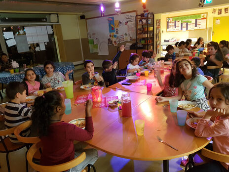 Gemeinsames Essen bei Kids Only-Jahresabschlussfeier im BewohnerInnen-Zentrum 
