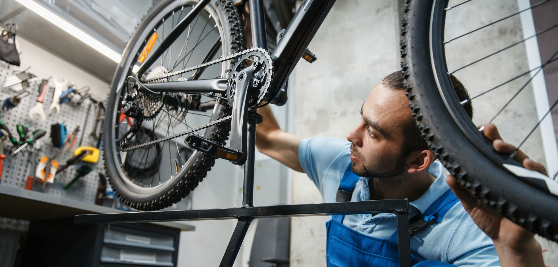 Ein Mann in einer Werkstatt, der ein Fahrrad repariert.