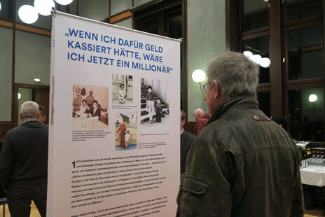 Besucher liest Ausstellungsbanner