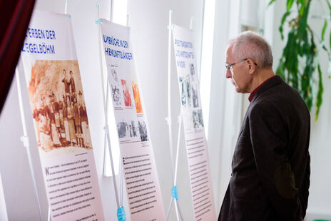 Besucher vor Ausstellungstafel