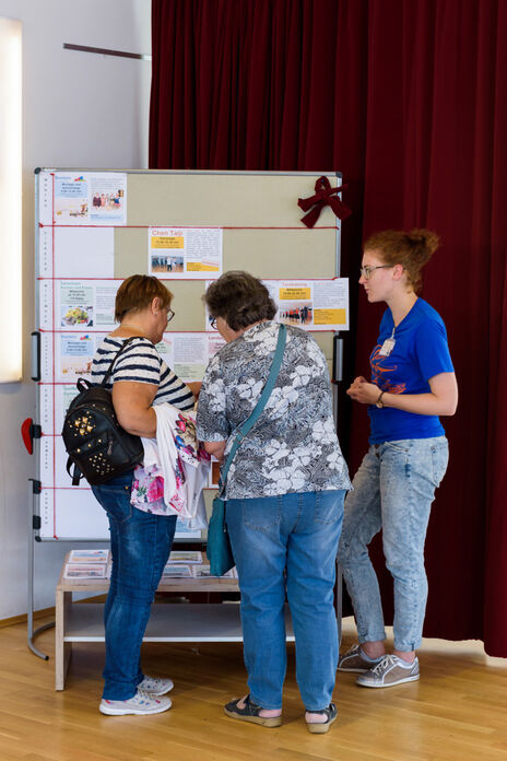 BesucherInnen betrachten Tafel zu Nachbarschaftsprojekten