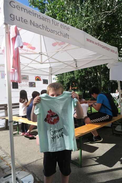 Kinder bei Zeit für Kreativität bemalen T-Shirts und Leinwände