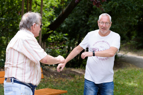 Zwei Männer beim Zumba-tanzen im Hof