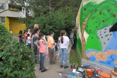 Gemeinsame Bemalung der Hauswände durch die Kinder der Wohnhausanlage. 