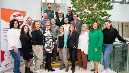 Gruppenbild der Abschlussklasse des wohnpartner Lehrgangs im inneren der Volkhochschule
