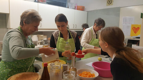 Bewohnerinnen in der Küche, kochen gemeinsam. 