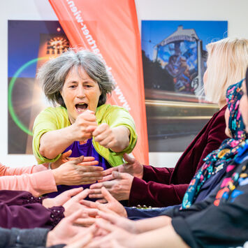 Teilnehmerinnen eines Workshops üben gemeinsam Selbstbehauptung und Körpersprache.
