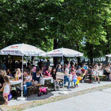 Alle Sitzplätze sind bei strahlendem Sonnenschein belegt.