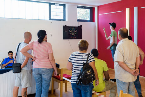 BesucherInnen beim Dartspielen