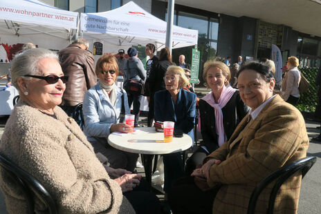 BesucherInnen des Festes genießen die Sonnenstrahlen.