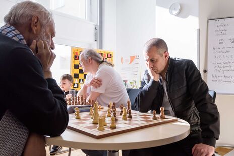 Besucher beim Schachspiel