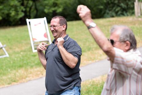 Zwei Männer beim Zumba-tanzen im Hof