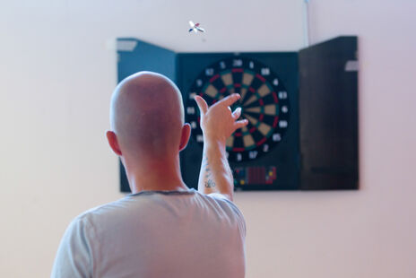 Besucher beim Dartspielen