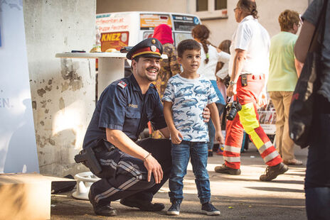 Ein kleiner Junge lässt sich mit einem Grätzelpolizisten fotografieren.