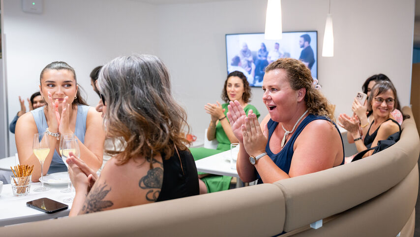 Mehrere Teilnehmerinnen der wohnpartner Akademie sitzen und applaudieren.