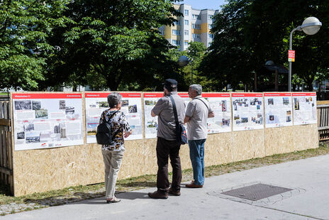 BesucherInnen betrachten die umfangreiche Freiluft-Ausstellung über die spannende Geschichte der Wohnhausanlage.