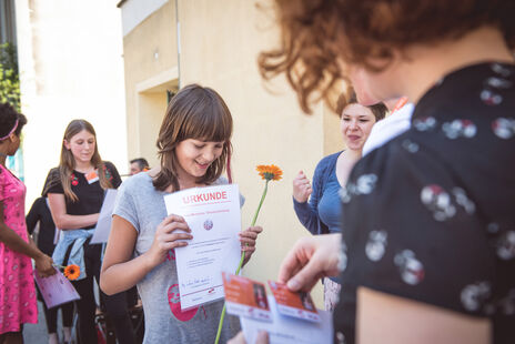 Schülerin nimmt ihr Diplom entgegen. 