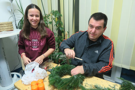 Pärchen beim gemeinsamen Adventkranzbinden