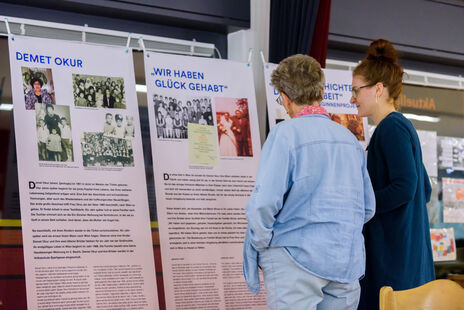 Besucherin und wohnpartner-Mitarbeiterin vor den Ausstellungstafeln