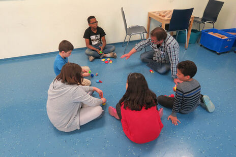 Die Kinder sitzen in Gruppen zusammen und besprechen das Gelernte.