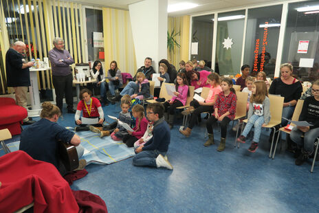 Kinder singen mit Gitarre-Spieler