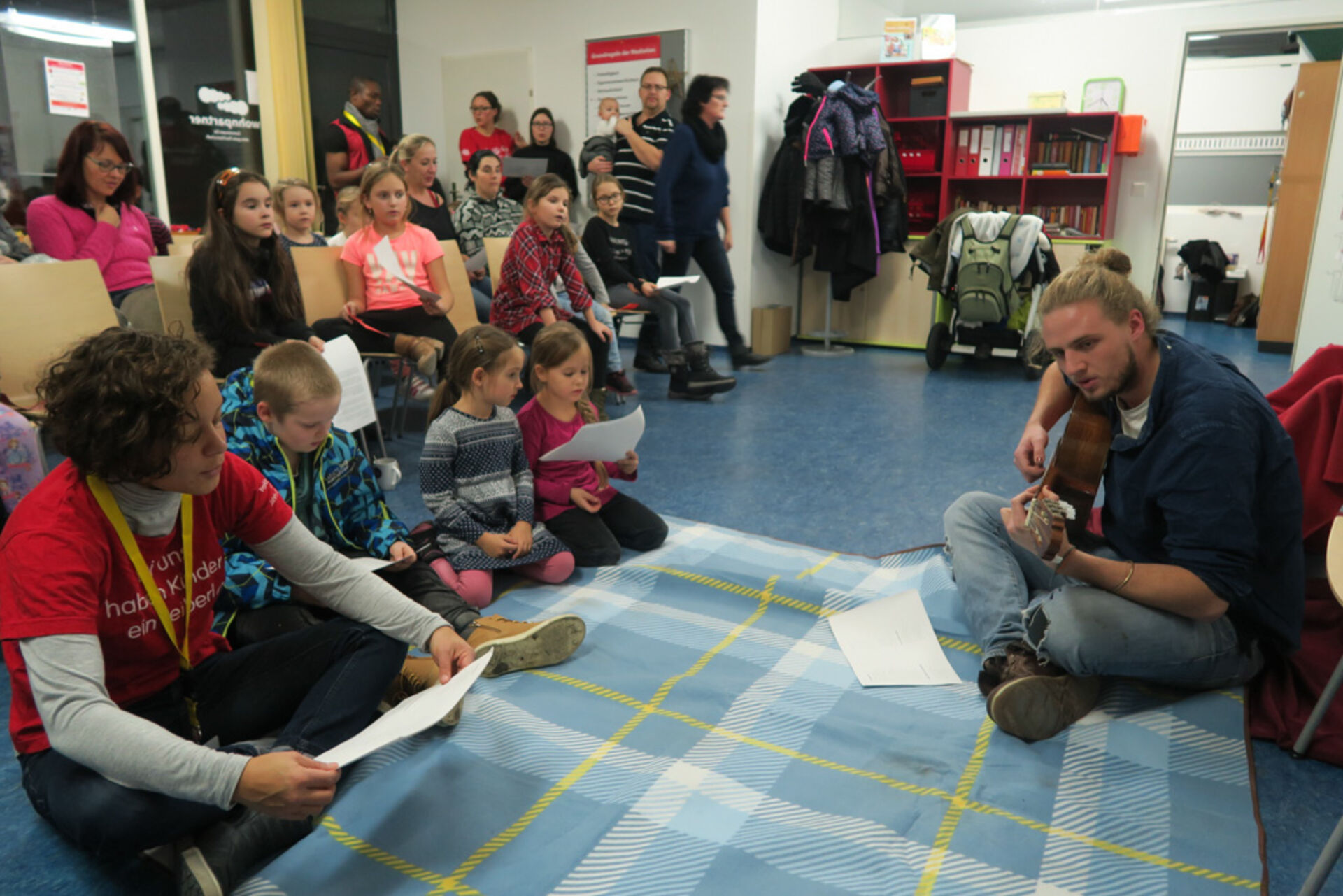 Kinder singen mit Gitarre-Spieler