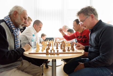 Besucher beim Schachspiel