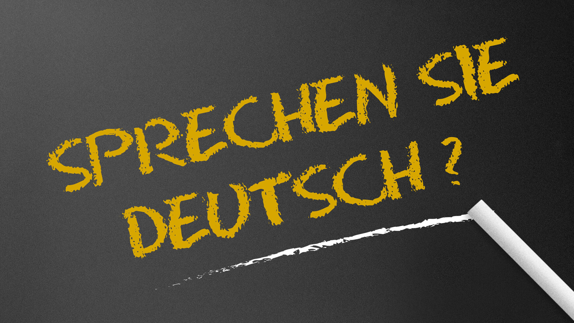 Der Schriftzug "Sprechen Sie Deutsch?" mit Kreide auf eine schwarze Tafel geschrieben