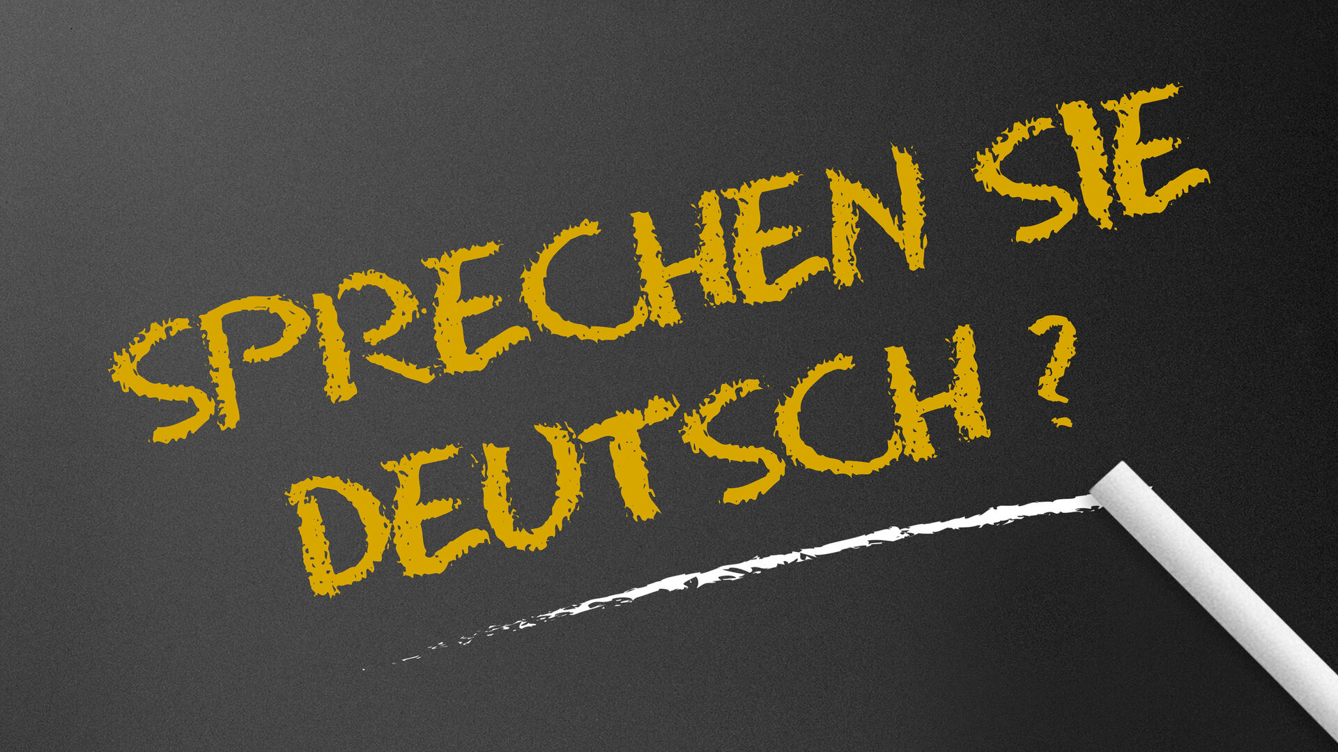 Der Schriftzug "Sprechen Sie Deutsch?" mit Kreide auf eine schwarze Tafel geschrieben
