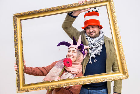 BesucherInnen halten Bilderrahmen für Foto