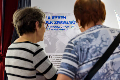 BesucherInnen vor einer Ausstellungstafel