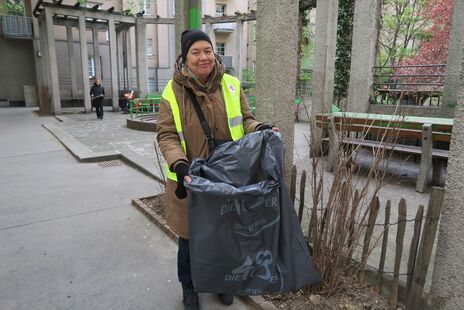 Bewohnerin mit Müllsack bei der Putzaktion