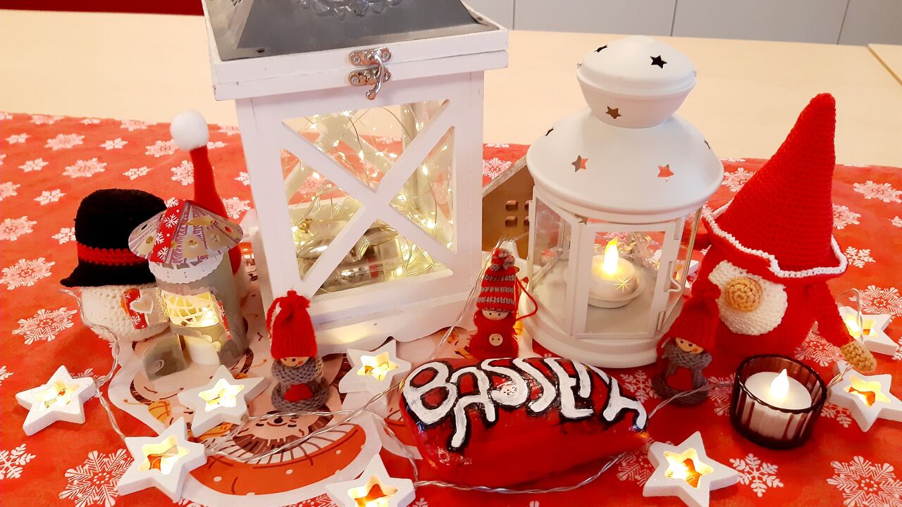 Weihnachtliche Dekoration auf einem roten Tischläufer mit Sternen 