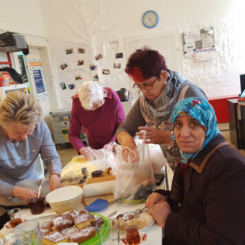Frauen des Frauencafé bereiten Tisch für gemeinsames Essen vor