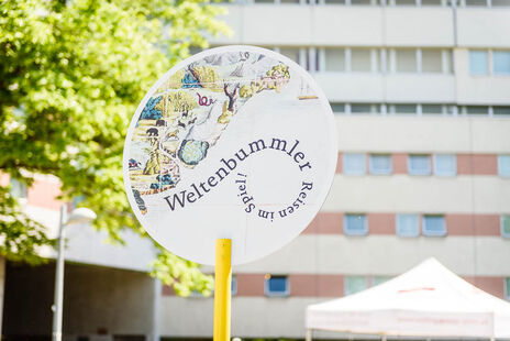 Schild: Weltenbummerl - Reisen im Spiel!