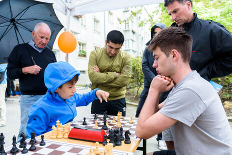 Der erst 17-jährige österreichische Nachwuchs-Star und Internationale Meister Valentin Dragnev spielt gegen einen kleinen Jungen.