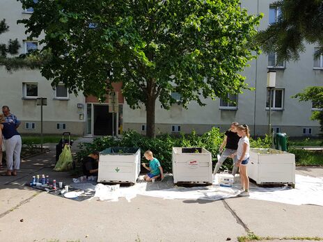 Bei strahlendem Sonnenschein bemalen Klein und Groß die Mobilen Beete