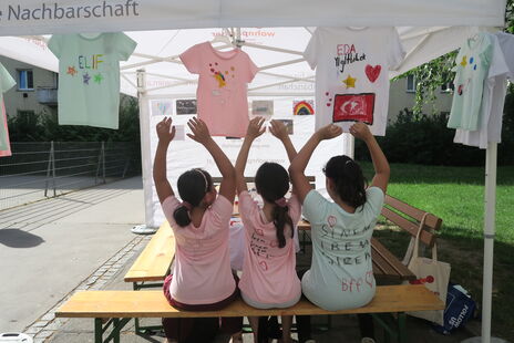 Kinder bei Zeit für Kreativität bemalen T-Shirts und Leinwände