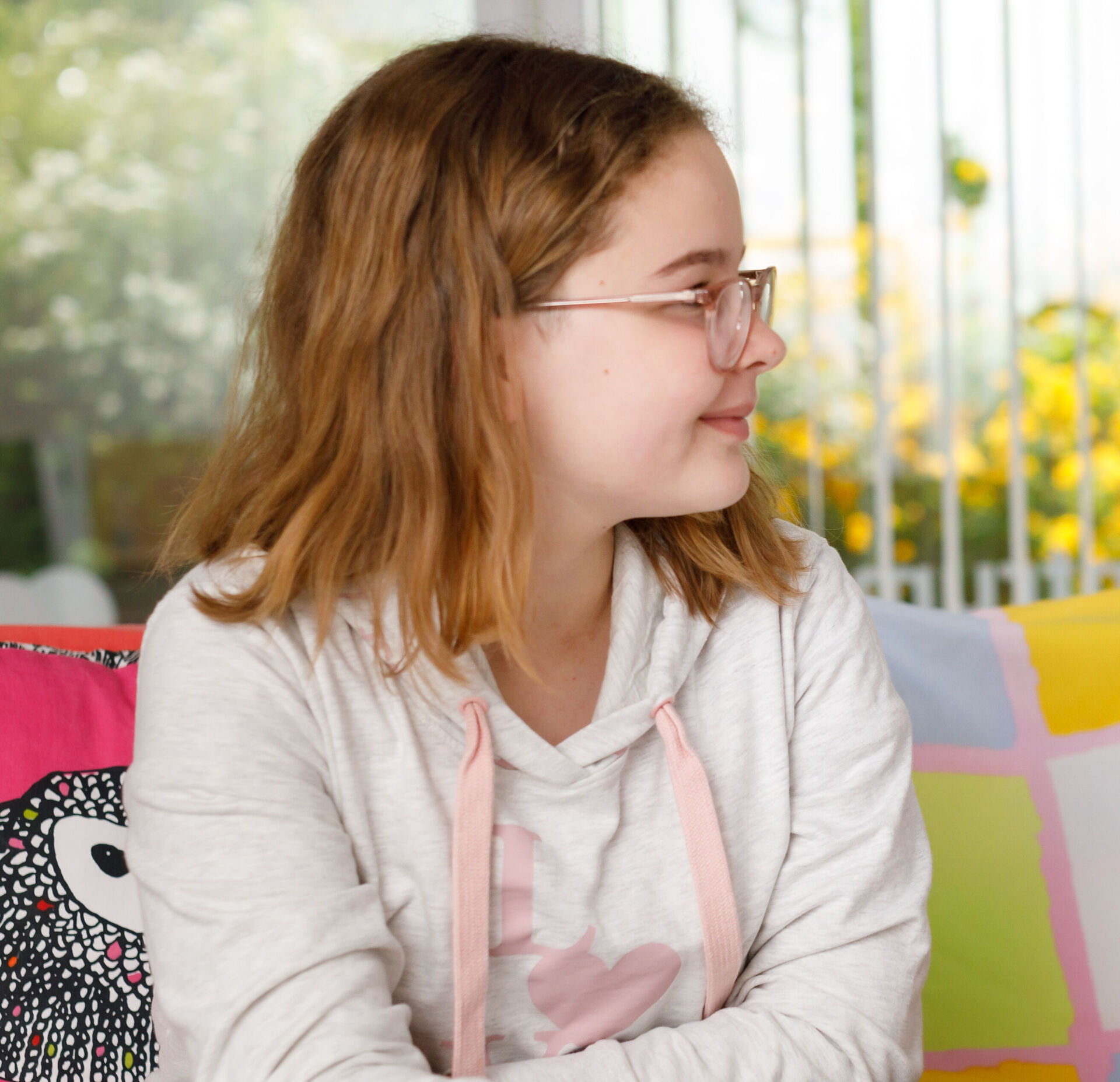 Ein Mädchen erhält Nachhilfe von einem etwas älteren Jungen. Die beiden sitzen an einem Tisch und schauen in ein Schulbuch.