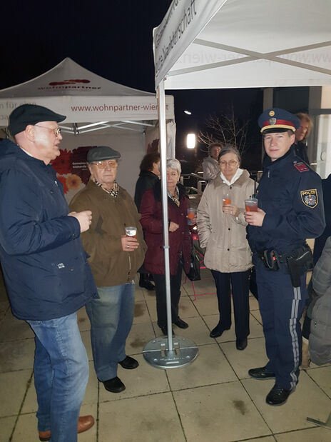 BewohnerInnen und Polizist beim gemeinsamen Feiern 