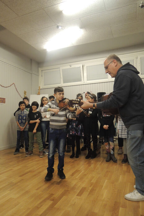 Geigenspielender Junge unterstützt den Kinderchor musikalisch beim Jahresausklang