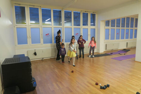 Die älteren Kids testen im Bewegungsraum mit viel Geschick und Feuereifer das neue Soft-Ball-Boccia.